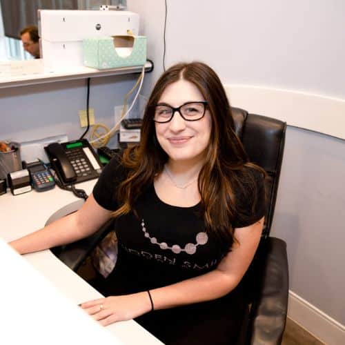 New patients 4 A woman sitting at a desk hidden smiles admin team