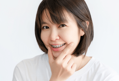 Invisalign vs traditional braces: the benefits at hidden smiles orthodontic studio 7 Woman holding chin in thinking pose, representing invisalign vs traditional braces