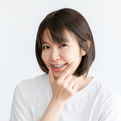 Invisalign vs traditional braces: the benefits at hidden smiles orthodontic studio 3 Woman holding chin in thinking pose, representing invisalign vs traditional braces