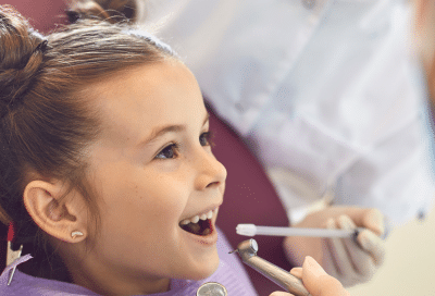 The importance of early orthodontic treatment: when and why your child should see an orthodontist 5 Little girl at the orthodontist getting her teeth checked, representing early orthodontic treatment