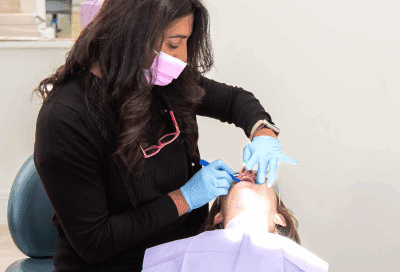 Celebrate orthodontic health month with orthodontic treatment in melville ny 9 Dr. Mita parikh working a patient's teeth, representing orthodontic health month