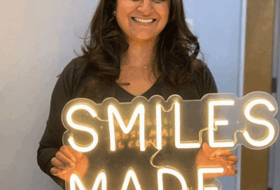 Understanding brava by brius: exploring this innovative orthodontic solution 10 Woman holding a lighted sign that reads smiles made here, representing brava by brius