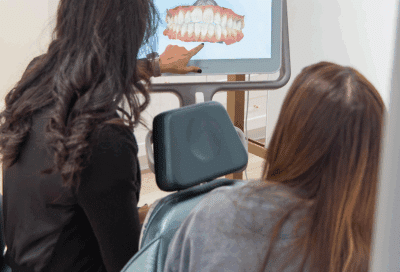 When to get braces: key signs it’s time for orthodontic treatment 8 Dr. Horton looking at a screen showing a jaw model to a patient, representing when to get braces