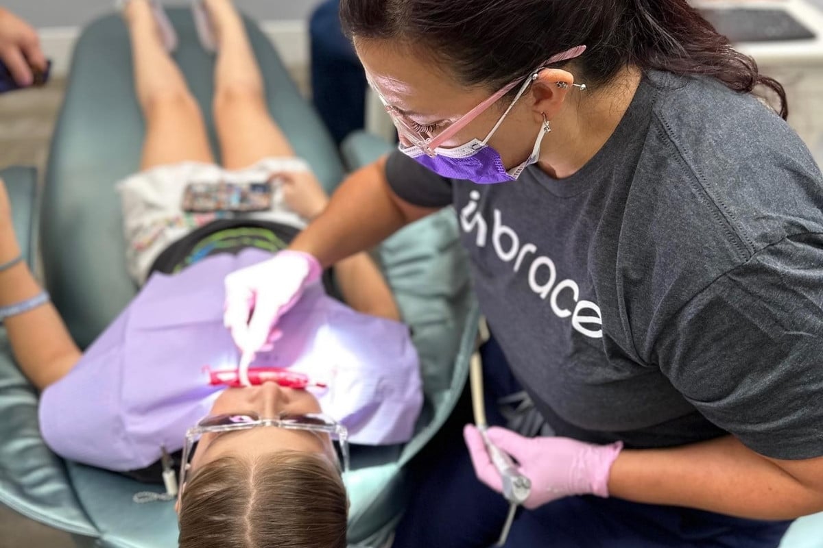 Hidden-smiles-early-orthodontics Orthodontic assistant performing early orthodontic treatment on a child patient in a dental chair
