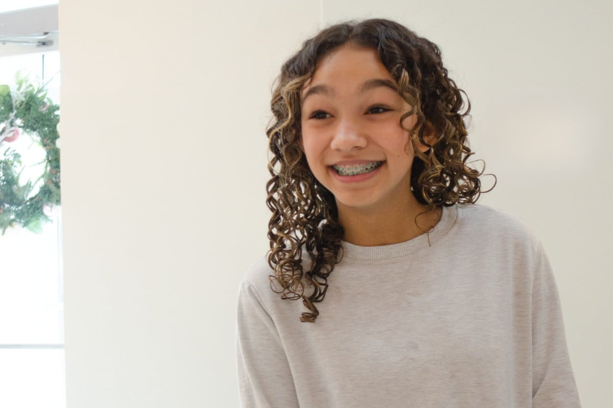 Hidden-smiles-orthodontics-for-teens Teen orthodontic patient smiling with braces at hidden smiles orthodontic studio