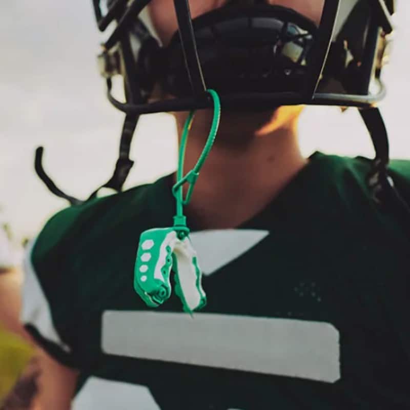 Hidden-smiles-trufit-close-up-sports-mouthguards Football player wearing a trufit custom sports mouthguard available at hidden smiles orthodontic studio in melville, ny for athletic dental protection.